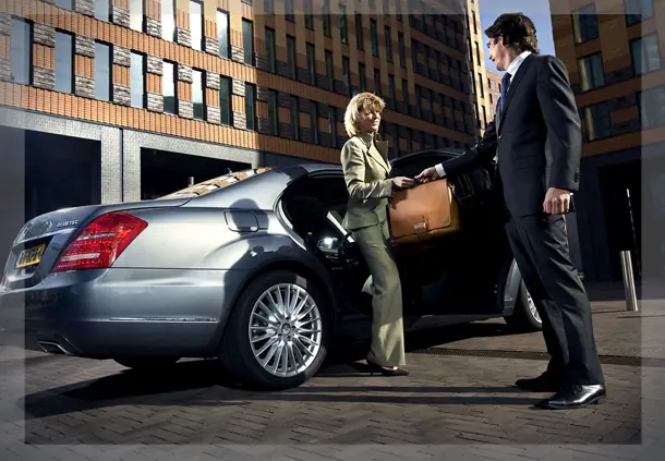 Chauffeur greeting a passenger at the car